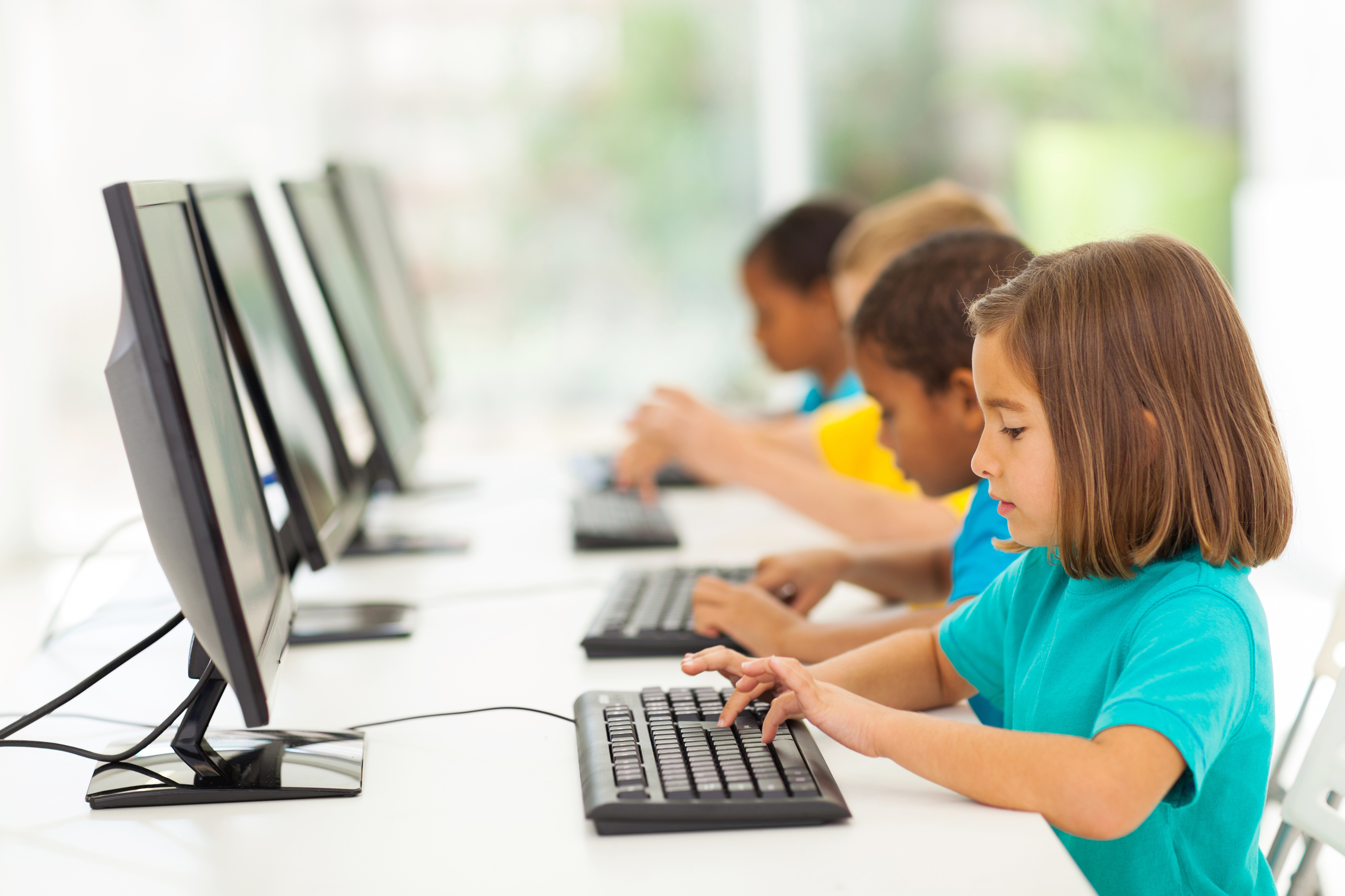 elementary school students typing on computers